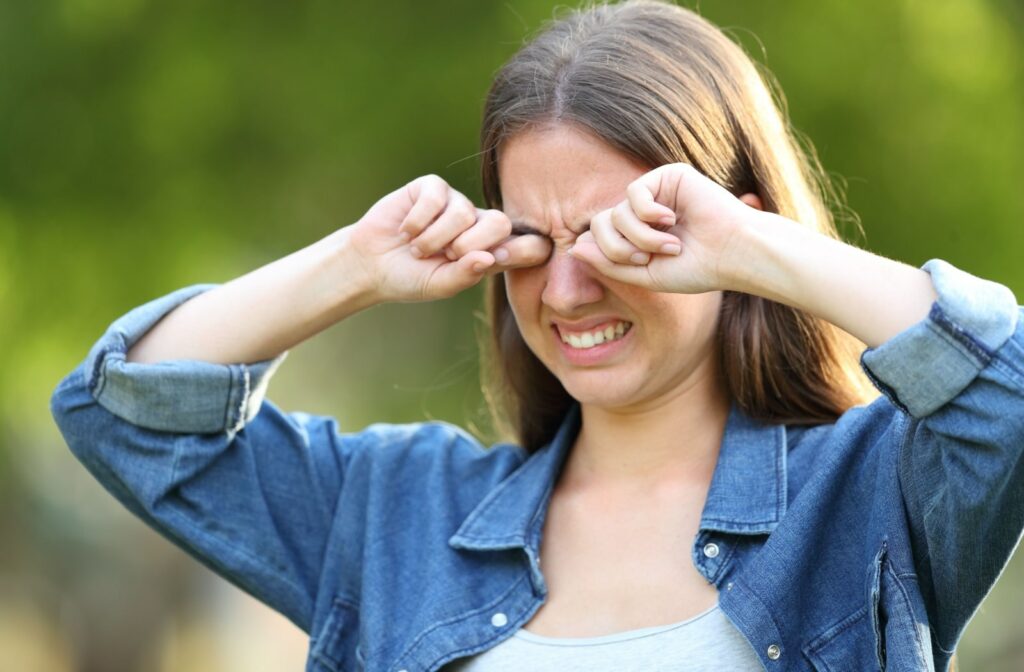 A woman aggressively rubbing her eyes.