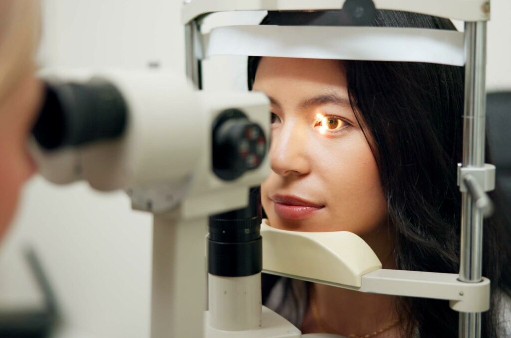 An optometrist carefully examining a patient's eyes up close using a slit lamp to determine what's causing their eye conditions and symptoms.