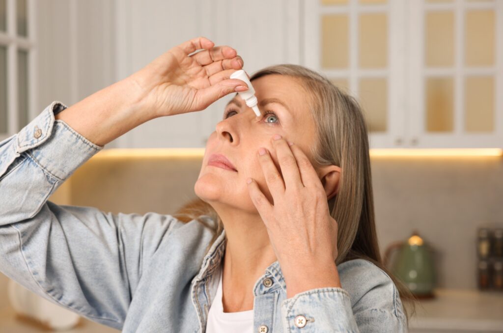 Woman holding eye drops, preparing to apply them to her eyes.