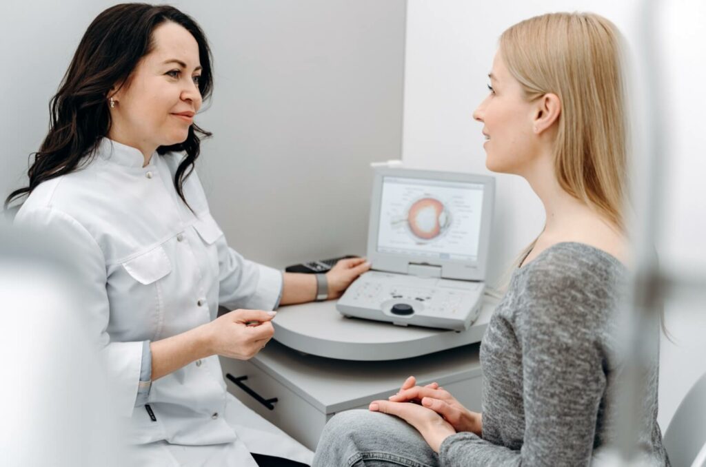 Optometrist examining a patient's eyes at an eye clinic during a check-up.