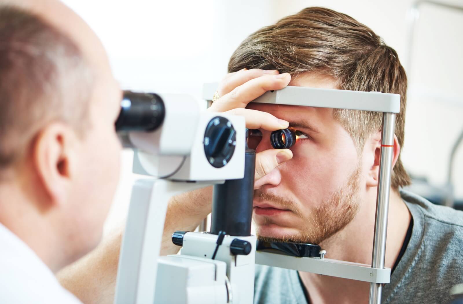 An optometrist evaluates their patient's eye health with a slit lamp.