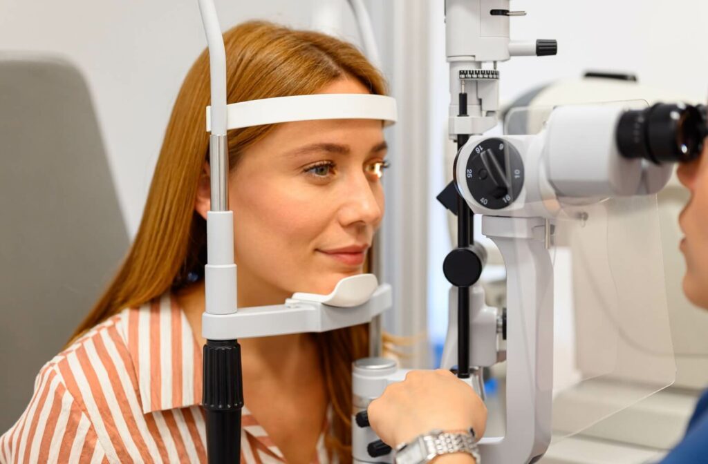 A person is undergoing a comprehensive eye exam with an optometrist using a slit lamp to accurately diagnose the cause of eye redness and irritation.